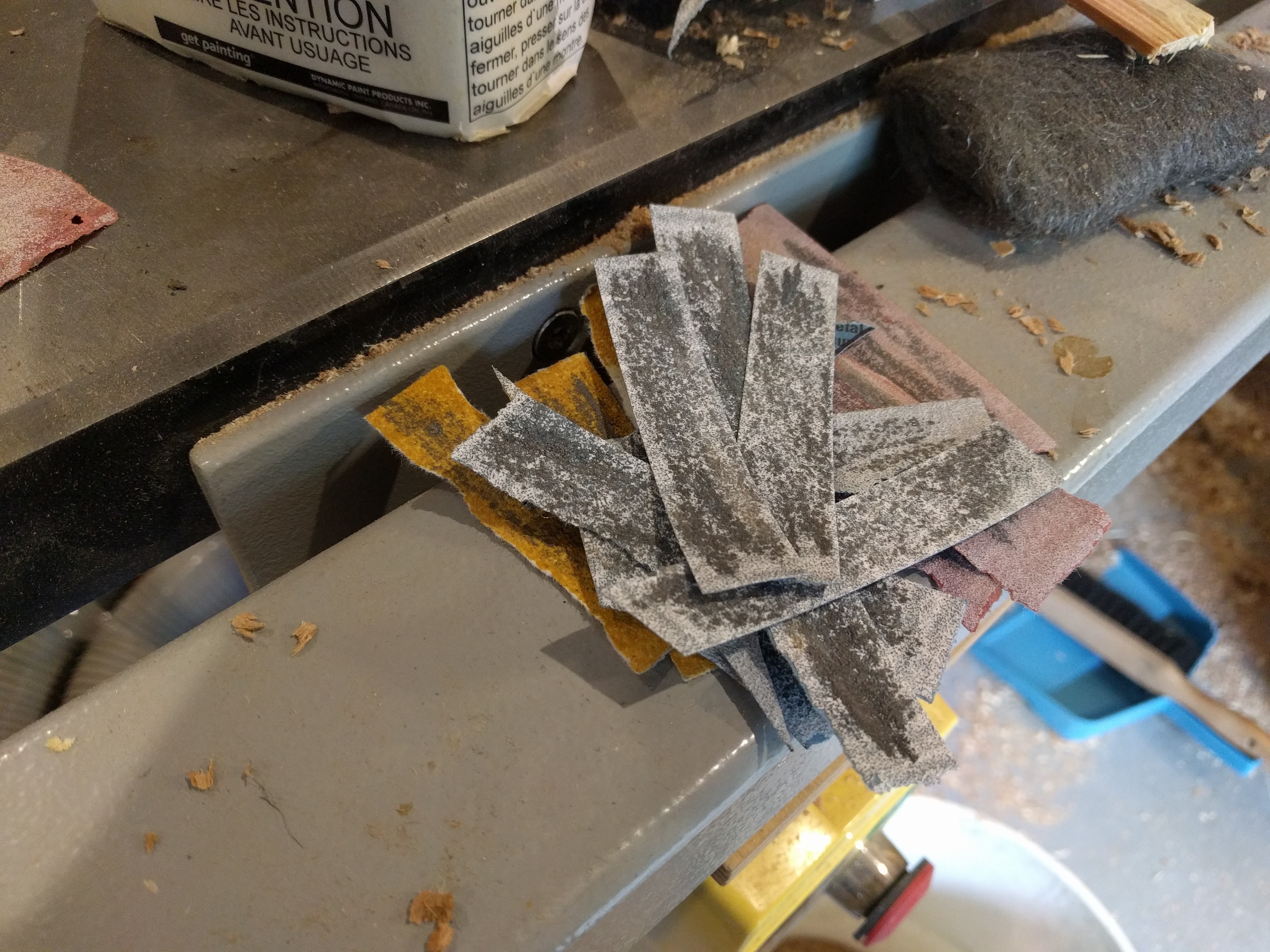 Sandpaper strips used to shape the stainless steel part.